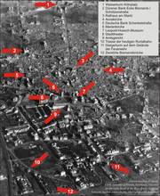 Die Grafik zeigt eine Luftbildansicht des völlig zerstörten Düren mit Hinweisen auf markante Punkte der Stadt.