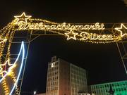 Lichterbogen mit Schriftzug Weihnachtsmarkt Düren, im Hintergrund das Rathaus Düren.